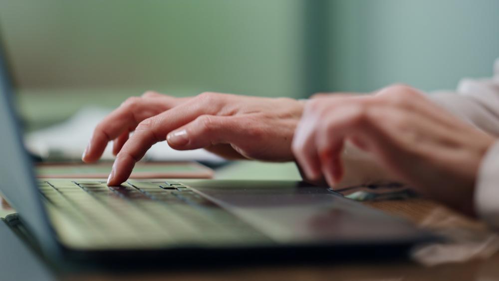 Hands on a keyboard writing a press release